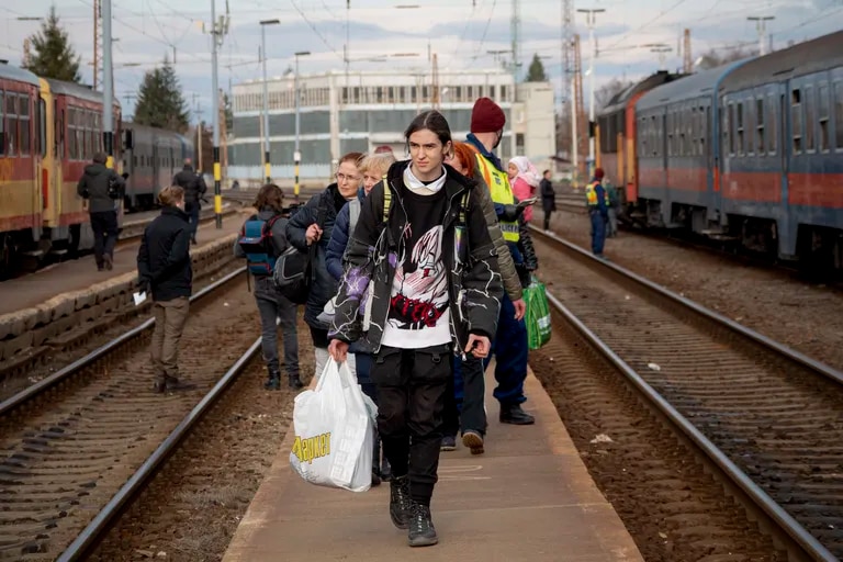 Refugiados que huyen de la guerra de la vecina Ucrania caminan in a andén tras bajar de un tren el miércoles 2 de marzo de 2022, en Zahony, Hungría.  (Foto AP / Balazs Kaufmann)